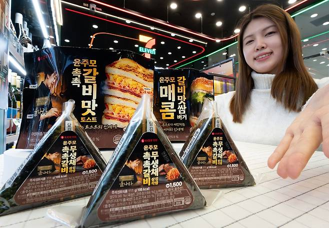 세븐일레븐 직원이 윤나라 셰프와 협업한 간편식을 소개하고 있다. [사진=세븐일레븐]