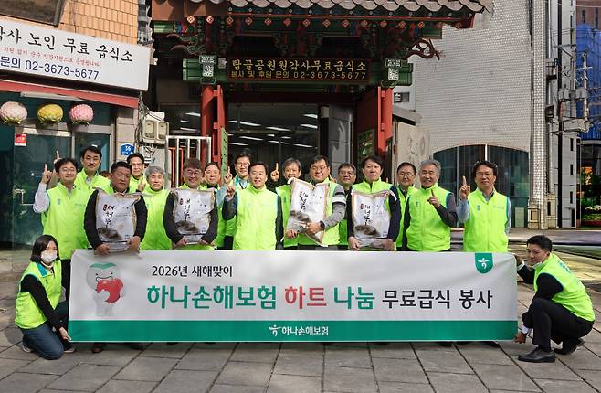 &nbsp;배성완 하나손해보험 대표이사(앞줄 왼쪽 세 번째)와 임직원들이 지난 19일 서울 종로구 탑골공원 원각사 노인 무료급식소에서 기념 촬영하고 있다. (사진=한화손해보험)