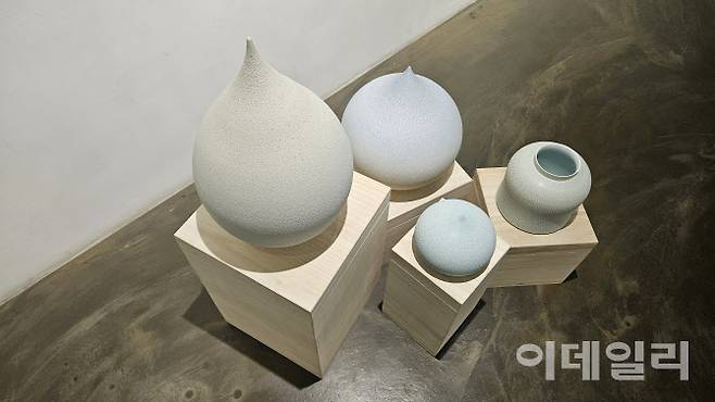 갤러리조은 ‘평온의 가장자리’ 전 전경. 바닥에 설치한 조원재의 ‘물방울’ 연작과 항아리 작품을 위에서 내려다봤다. ‘순간의 가장자리’(2025), ‘푸른 물방울’(2025) 곁에 ‘2023-푸른호-017’(2023, 21×21×20㎝·오른쪽)가 놓였다(사진=오현주 문화전문기자).