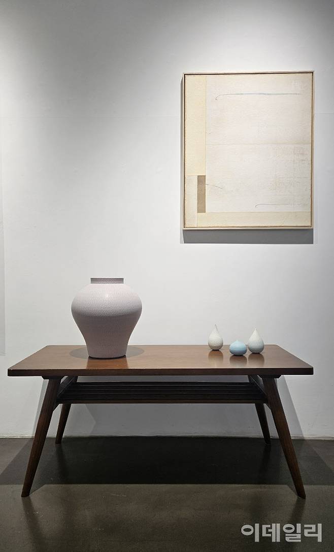 갤러리조은 ‘평온의 가장자리’ 전 전경. 작가 성연화의 작품과 조우한 조원재의 작품들이 2인전의 특별한 풍경을 만들어내고 있다. 탁자 위에 설치한 조원재의 작품 ‘분홍빛 호’(2023, 30×30×33㎝·왼쪽)와 ‘매우 작은 순간의 가장자리’(2025) 연작 위로 성연화의 한지회화 ‘평온’(Serenity 2025)이 걸렸다(사진=오현주 문화전문기자).