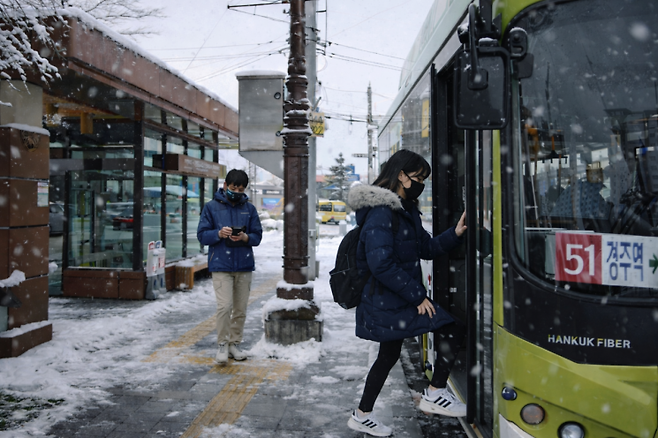 눈 내리는 날 경주 황성공원·시립도서관 버스정류장에서 청소년들이 시내버스에 탑승하고 있다. 경주시 제공