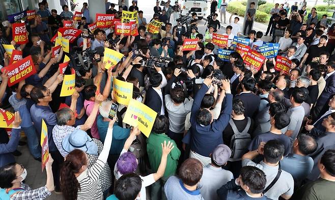 전북 완주군과 전주시의 지역 간 통합을 추진 중인 김관영 전북도지사가 2024년 7월26일 군민과의 대화가 예정된 완주문화예술회관 안으로 들어가려고 하자 통합 찬성과 반대 주민들이 몰려들어 손팻말을 들고 있다. 이날 군민과의 대화는 무산됐다. 연합뉴스