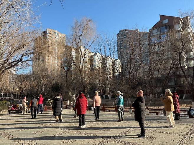 중국의 고령화 속도가 빨라지면서 젊은층의 부양 부담이 눈덩이처럼 불고 있다. 베이징 차오양구의 한 아파트 단지 공원에서 고령자들이 체조를 하고 있다. 베이징=김은정 특파원