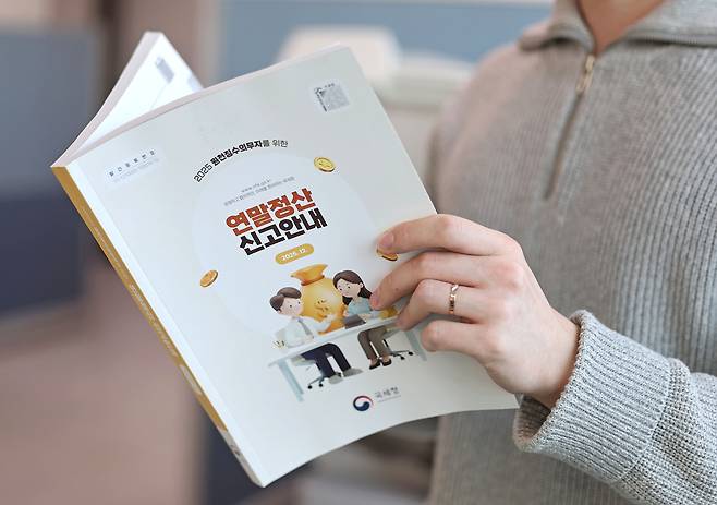 연말정산 간소화 서비스 개통을 하루 앞둔 지난 14일 서울 종로세무서에서 법인세과 직원들이 연말정산 신고 안내 책자를 살펴보고 있다. 연합뉴스