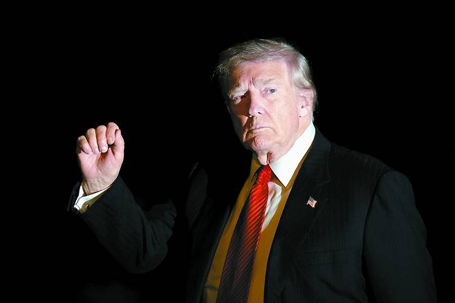 President Donald Trump is illuminated by a camera flash as he gestures while walking across the South Lawn of the White House in Washington after returning from a trip to Florida on Nov. 2, 2025. [AP/YONHAP]