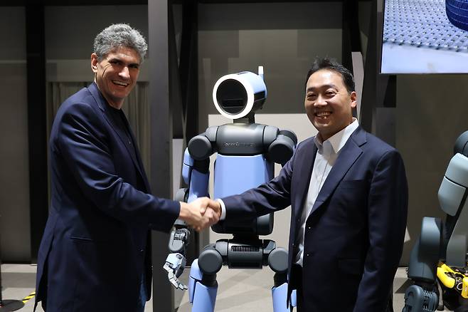 Zack Jackowski, left, head of humanoid development at Boston Dynamics, and Oh Se-uk, head of the Robotics Business Innovation Group at Hyundai Mobis, take a photo with the Atlas humanoid robot after an interview with the Korean press on the sidelines of CES 2026 in Las Vegas on Jan. 7. [HYUNDAI MOTOR]