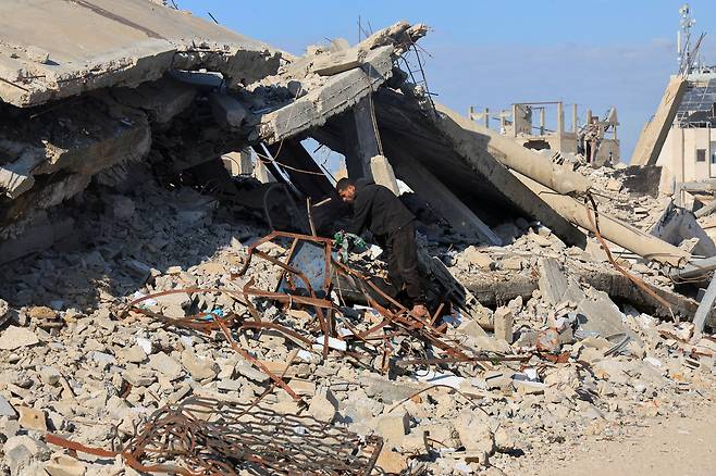 A Palestinian national searches for several relatives who remain under the rubble of his house, which was destroyed in Israeli strikes during the war, in Khan Younis in the southern Gaza Strip on Jan. 17. [REUTERS/YONHAP]