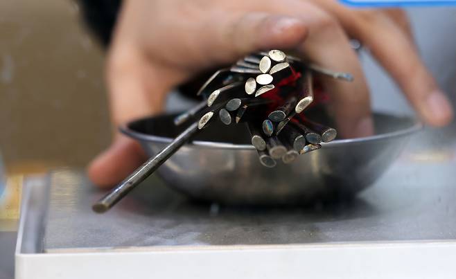 A worker at the Korea Gold Exchange in Jongno District, central Seoul, weighs silver spoons a customer seeks to sell on Jan. 20. Gold and silver prices hit record highs as U.S. President Donald Trump signaled additional tariffs on European nations in pursuit of securing Greenland. Spot silver rose 5 percent compared to the previous day to $94.10 per ounce, extending its gains to 18 percent so far this year. [YONHAP]