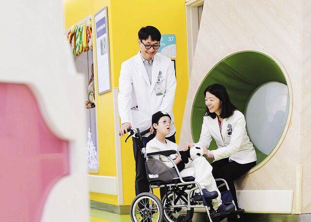 서울대병원이 생산한 카티 치료제로 건강을 회복한 급성림프모구성백혈병 환아 신이현군이 지난달 중순 서울 서대문구 세브란스병원에서 소아청소년과 한승민(오른쪽) 교수 등 담당 의료진과 시간을 보내고 있다. 박순재 사진작가 제공