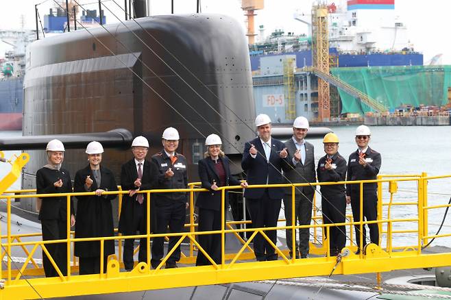 멜라니 졸리 캐나다 산업부 장관(가운데)이 지난해 11월 한화오션 거제사업장에서 김희철 한화오션 대표이사(왼쪽 네 번째), 강환석 방위사업청 차장(왼쪽 세 번째) 등과 장영실함을 배경으로 단체사진을 찍고 있는 모습. /사진=한화오션