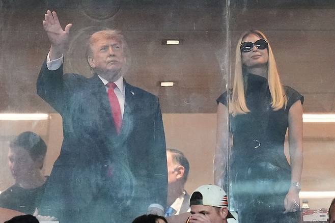 [마이애미가든스=AP/뉴시스] 도널드 트럼프 미국 대통령이 19일(현지 시간) 딸 이방카와 함께 미국 플로리다 마이애미가든스에서 열린 대학 미식축구 결승전을 관람하고 있다. 트럼프 대통령은 이번 주 스위스 다보스에서 열리는 세계경제포럼(WEF) 회의를 계기로 그린란드 관련 회의를 갖기로 합의했다고 발표했다. 2026.01.20.