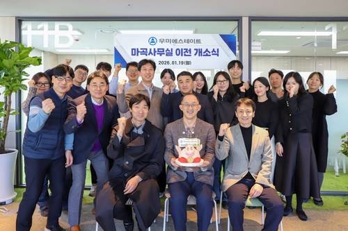 김정훈(가운데) 우미에스테이트 대표와 임직원들이 19일 서울 강서구 마곡 뉴브 클라우드힐스에서 열린 사무실 이전을 기념하며 기념촬영을 하고 있다. 사진 제공=우미건설
