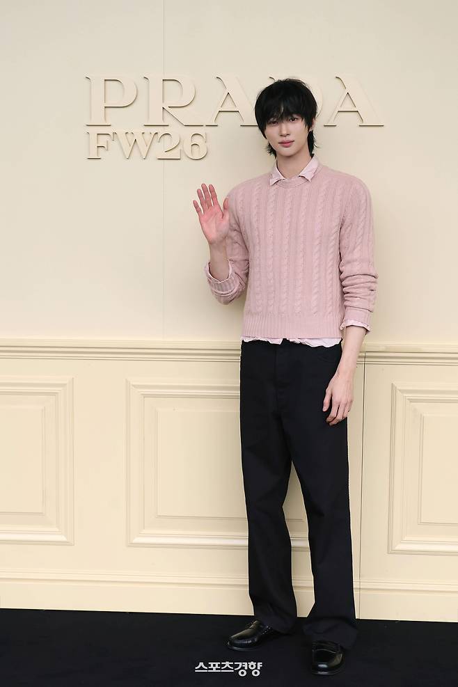 Actor Byeon Woo-seok wearing a pink cable knit and black trousers