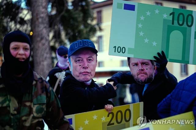 스위스 다보스에서 열리는 세계경제포럼(WEF) 연례 총회를 반대하는 시위자들이 18일(현지시간) 세계 최고 부자 일론 머스크 테슬라 최고경영자(가운데)와 JD밴스 미국 부통령(오른쪽)의 가면을 쓰고 행진하고 있다. AP 연합뉴스