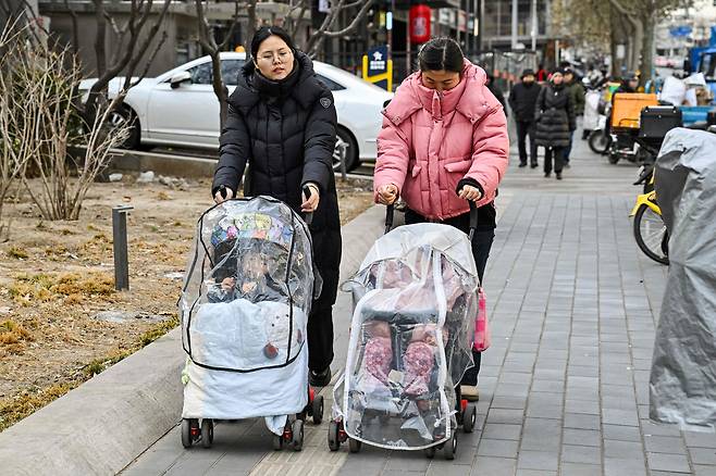 지난 4일(현지시간) 중국 베이징의 한 거리에서 여성들이 유모차를 밀며 걷고 있다. AFP=연합뉴스