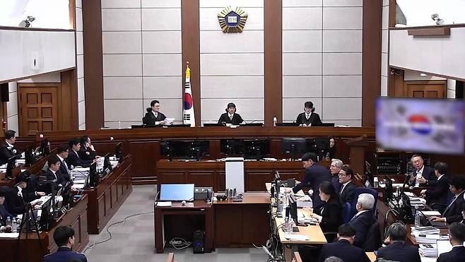 윤석열 전 대통령이 13일 오후 서울 서초구 서울중앙지방법원에서 진행된 내란 우두머리 혐의 2차 결심공판에 출석해 자리에 앉아 윤갑급 변호사와 대화를 하고 있다. 사진 서울중앙지법