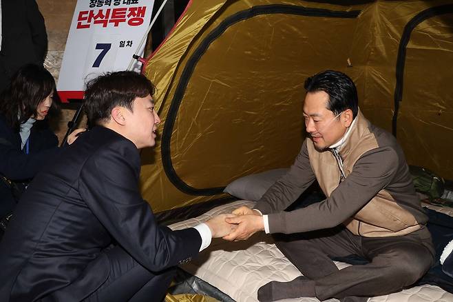 이준석 개혁신당 대표(왼쪽)가 21일 서울 여의도 국회 로텐더홀에서 단식투쟁 일주일째를 맞은 장동혁 국민의힘 대표의 농성장을 찾아 대화를 하고 있다. 뉴스1