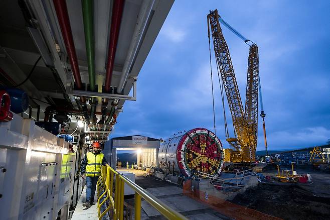 A worker walks past the assembly site of a tunnel boring machine at the construction site of the Palermo-Catania-Messina high-capacity railway line at the Enna-Dittaino section in Sicily, Italy, on February 19, 2025. [REUTERS/YONHAP]