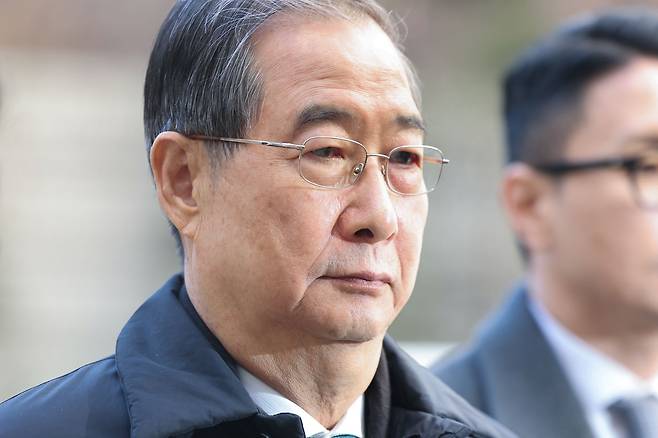 Former Prime Minister Han Duck-soo, who is accused of aiding and abetting the alleged ringleader of an insurrection, heads to the courtroom to attend an initial sentencing hearing at the Seoul Central District Court on Jan. 21. [YONHAP]