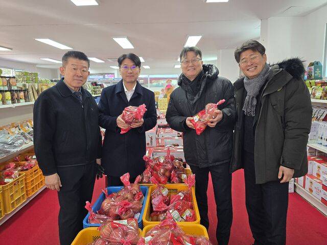김명규 강원 화천농협 조합장(왼쪽부터), 김병용 강원농협본부장, 이명호 NH농협은행 강원본부장 등이 화천산천어축제장 내에 마련된 화천농협 농산물 판매장에서 화천산 사과를 살펴보고 있다.