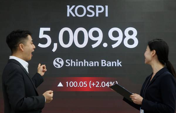 코스피가 장중 5,000을 넘어선 가운데 22일 서울 중구 신한은행 본점 로비에서 딜러들이 미소 짓고 있다. 2026.1.22 /신한투자증권 제공