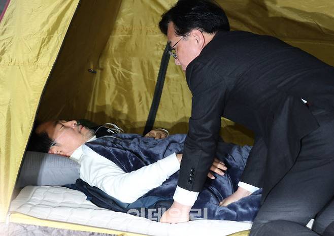 [이데일리 노진환 기자] 통일교 및 공천헌금 특검 수용을 촉구하며 8일째 단식을 이어가고 있는 장동혁 국민의힘 대표가 22일 서울 여의도 국회 로텐더홀 농성장에 마련된 텐트 안에 누워 있다. 송언석 원내대표가 최고위원회의 시작 전 장 대표를 찾아 보고 있다.
