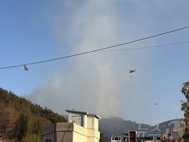 22일 오전 9시쯤 옥곡면사무소에 마련된 임시 대피소에서 바라 본 화재현장. 21일에 비해 연기가 조금씩 잦아들고 있다. ⓒ News1 김성준 기자