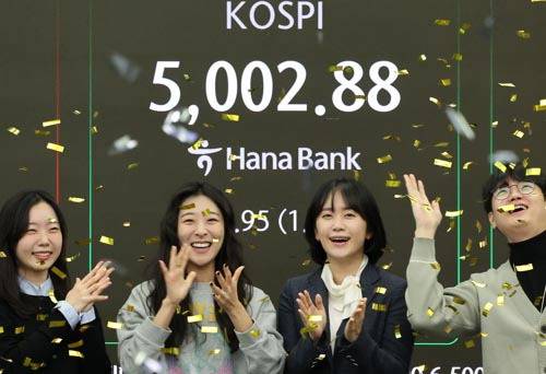 22일 오전 서울 중구 하나은행 딜링룸에서 딜러들이 코스피 지수가 장중 5000을 넘어서자 기뻐하고 있다. 연합뉴스