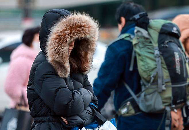 People clad in thick coats are seen crossing a street near Gwanghwamun Square in Jongno District, central Seoul, on Jan. 22. [NEWS1]