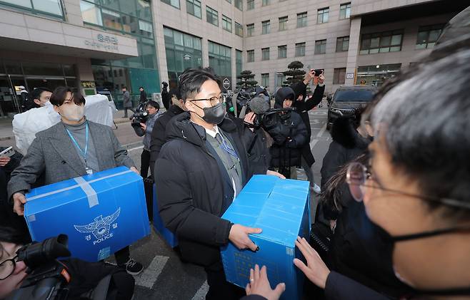 Police officers remove seized materials from an engineering building at a university in Seoul on Jan. 21, during raids conducted by a joint military-police task force investigating North Korea’s claims of South Korean drone infiltration. The building was attended by suspects surnamed Jang and Oh. [YONHAP]