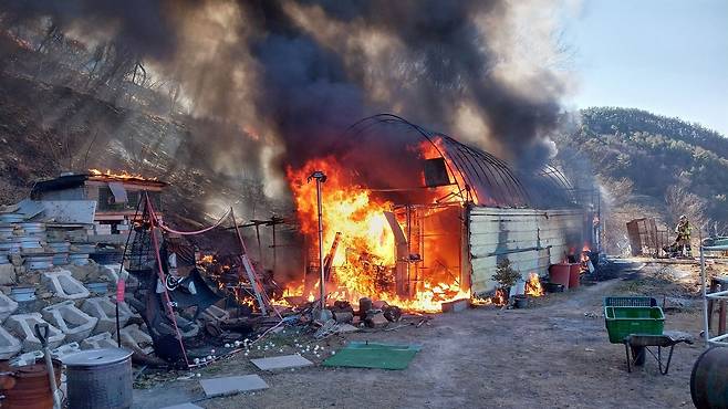 Forestry authorities battle a fire after flames break out at a farm shed used as a storage space in Jiphyeon-myeon, Jinju, South Gyeongsang, and spread to a nearby wooded hill on Jan. 22. [NORTH GYEONGSANG FIRE SERVICE HEADQUARTERS]