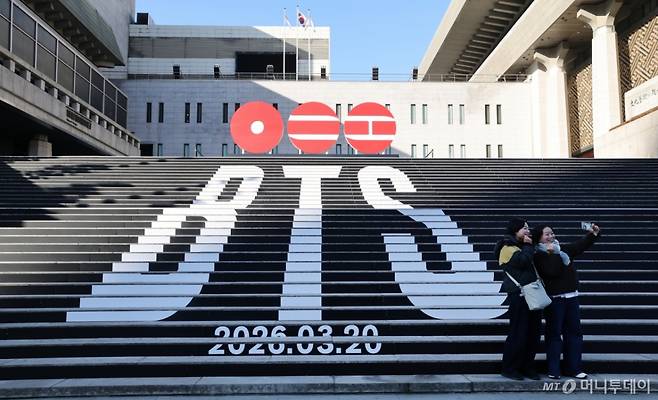 (서울=뉴스1) 임세영 기자 = 6일 오전 서울 종로구 세종문화회관 야외 계단에 설치된 BTS(방탄소년단)의 컴백 로고 조형물 앞에서 관광객들이 기념촬영을 하고 있다.  BTS는 3월 20일 컴백과 새 앨범 발매, 월드투어 일정을 공식 발표했다. 2026.1.6/뉴스1  Copyright (C) 뉴스1. All rights reserved. 무단 전재 및 재배포,  AI학습 이용 금지. /사진=(서울=뉴스1) 임세영 기자