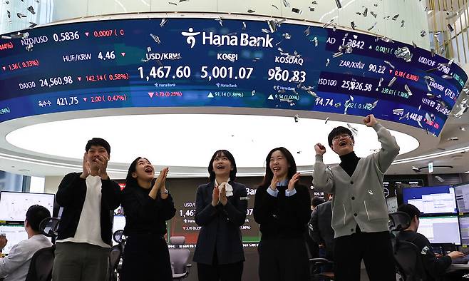 코스피가 꿈의 숫자로 여겨지던 '오천피'에 도달하며 코스피 5000 시대가 열린 22일 오전 서울 중구 하나은행 딜링룸에서 관계자들이 코스피 5000 돌파를 축하하고 있다. 뉴시스