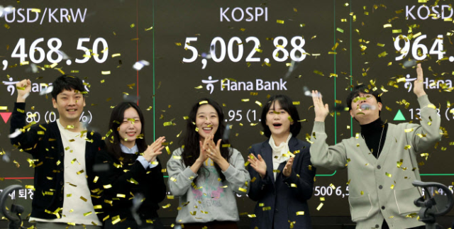 코스피가 장중 5,000을 넘어선 가운데 22일 오전 서울 중구 하나은행 딜링룸에서 딜러들이 기뻐하고 있다. 연합뉴스