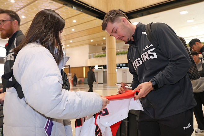 KIA 아시아쿼터 제러드 데일이 22일 김포공항 출국장에서 만난 팬에게 사인을 하고 있다. KIA 타이거즈 제공