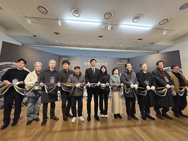 테이프 커팅하는 데브시스터즈와 전통예술 장인들     (서울=연합뉴스) 김주환 기자 = 국내 게임사 데브시스터즈 관계자들과 전통 공예 장인들이 22일 서울 인사동 아라아트센터에서 열린 '쿠키런: 킹덤' 아트 컬래버 특별전 '위대한 왕국의 유산' 기자 간담회 자리에서 한지로 된 기념 테이프를 자르고 있다. 2026.1.22 jujuk@yna.co.kr