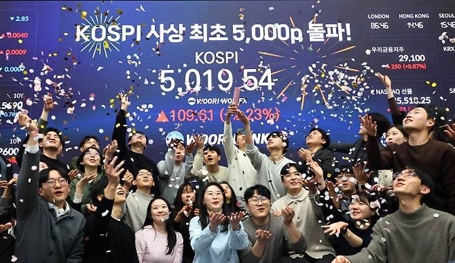 코스피 지수가 장중 사상 처음으로 5019.54를 기록한 22일 서울 중구 우리은행 본점 딜링룸에서 딜러들이 코스피 지수 5000선 돌파를 축하하고 있다.(사진=연합뉴스)