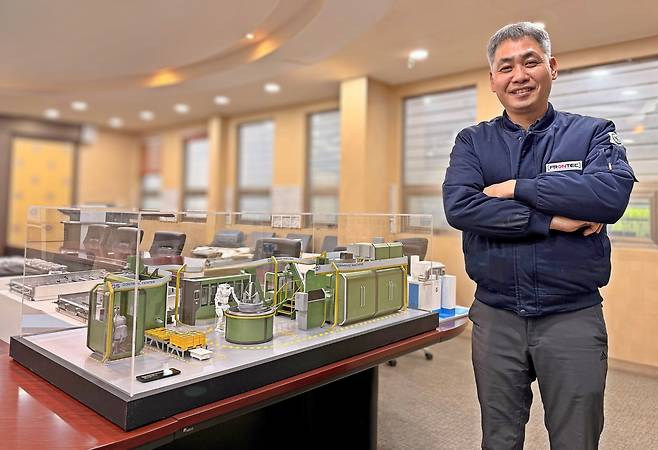 민수홍 프론텍 대표가 지난 9일 마이크로 팩토리 모형 옆에서 사진을 촬영하고 있다./홍인석