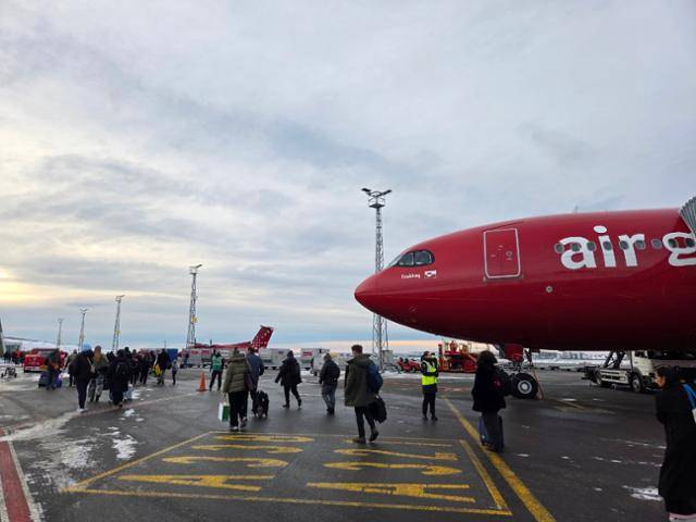 22일 그린란드 수도 누크 공항에 도착한 여객기에서 승객들이 내려 이동하고 있다. 누크=정승임 특파원