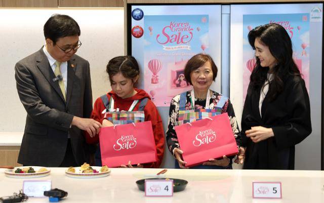 최휘영(맨 왼쪽) 문화체육관광부 장관과 이부진(맨 오른쪽) 한국방문의해위원회 위원장이 22일 서울 영등포구 더현대 서울 문화센터의 '케이(K)-소스 활용 한식 쿠킹클래스' 중 외국인 관광객들에게 선물을 전달하고 있다. 문체부 제공