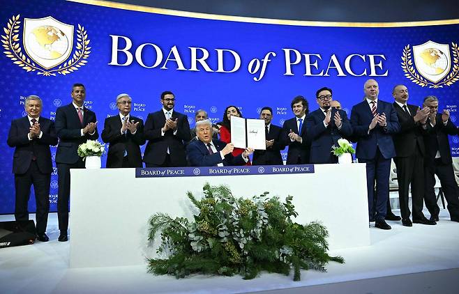 도널드 트럼프 미국 대통령이 22일(현지시간) 평화위원회 창립 헌장에 서명한 뒤 참여국 정상들과 박수를 치고 있다. [AFP=연합뉴스]