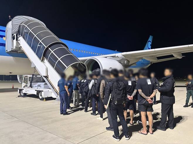 범죄인들이 23일 새벽 캄보디아 프놈펜 테초국제공항에서 전세기에 탑승하고 있다./경찰청 제공
