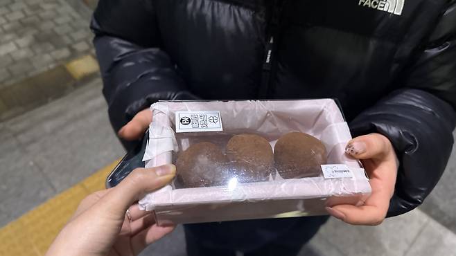 I gift three Dubai chewy cookies to a friend who biked 30 minutes at night to receive edible gold. [WOO JI-WON]