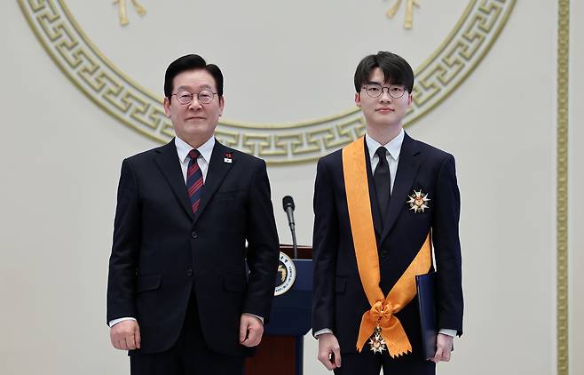 President Lee Jae Myung, left, poses with Lee Sang-hyeok, better known as League of Legends world champion "Faker," after presenting him with the Cheongnyong Medal, the nation’s highest sporting honor, during the 2026 New Year’s gathering at the state guesthouse of the Blue House in central Seoul on Jan. 2. [NEWS1]