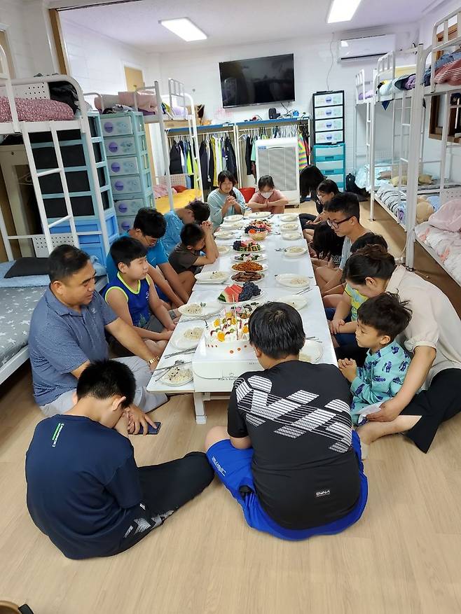 황희수(왼쪽 두 번째)목사가 2023년 7월 탈북 중도입국자 남자 기숙사에서 생일을 맞이한 아이들에게 축복기도를 하고 있다.