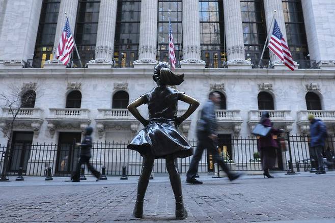 뉴욕증권거래소(NYSE) 앞에 설치된 ‘두려움 없는 소녀(The Fearless Girl)’ 동상 앞을 사람들이 지나가고 있다. (사진=AFP)
