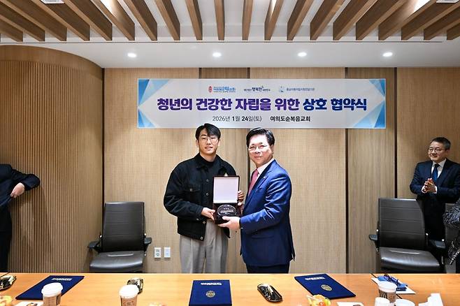 24일 오전 서울 영등포구 여의도순복음교회 비서실에서 열린 ‘청년의 건강한 자립을 위한 상호협약식’에서 이영훈 목사가 자립준비청년 박정재씨에게 표창장을 수여한 이후 찍은 사진. 여의도순복음교회 제공