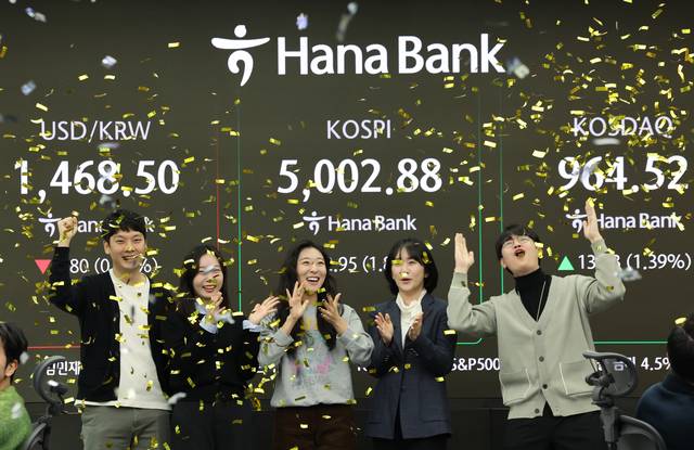 코스피가 장중 5,000을 넘어선 가운데 22일 오전 서울 중구 하나은행 딜링룸에서 딜러들이 기뻐하고 있다. 연합뉴스