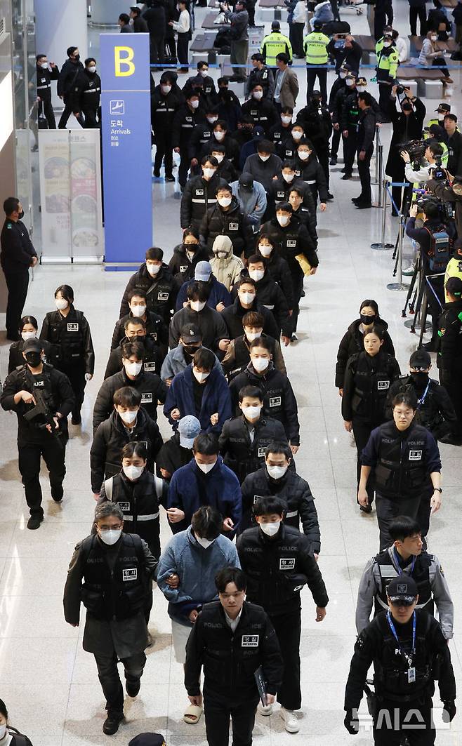 [인천공항=뉴시스] 김진아 기자 = 한국 국적 캄보디아 스캠조직 피의자들이 23일 오전 인천국제공항 제2터미널을 통해 강제 송환되고 있다.  초국가범죄 특별대응 TF는 캄보디아를 거점으로 우리 국민 869명에게 약 486억원을 편취한 한국 국적 피의자 73명을 강제 송환했다. 2026.01.23. bluesoda@newsis.com