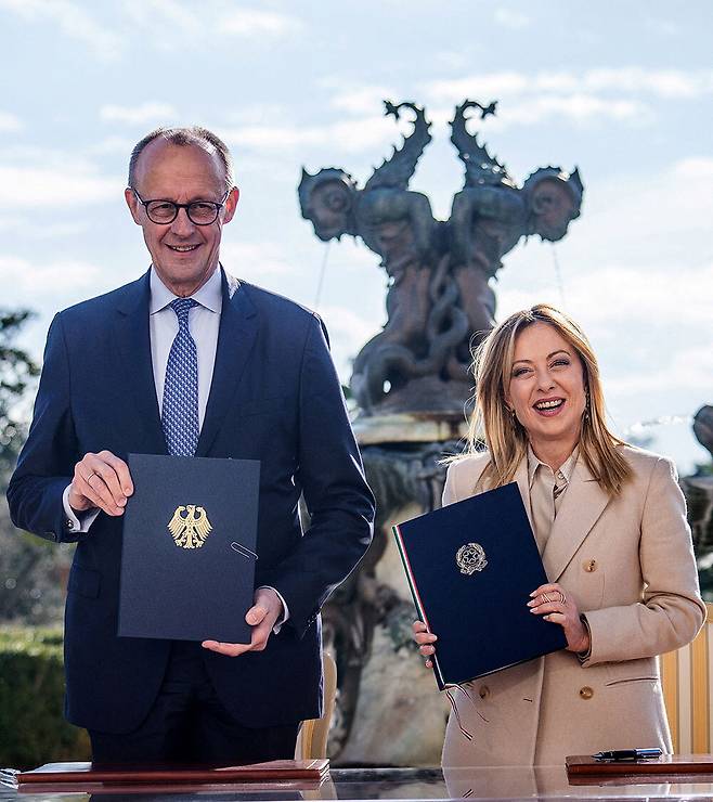 23일(현지시간) 로마에서 정상회담을 한 프리드리히 메르츠 독일 총리(왼쪽)와 조르자 멜로니 이탈리아 총리가 양국 간&nbsp;경제 및 군사 분야 협력에 합의한 뒤 나란히&nbsp;협정문을 든 채 기념 촬영을 하고 있다. 로이터연합뉴스